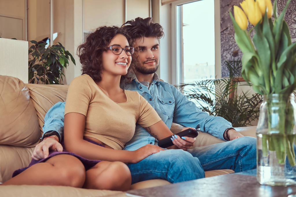 couple cuddling while watching TV