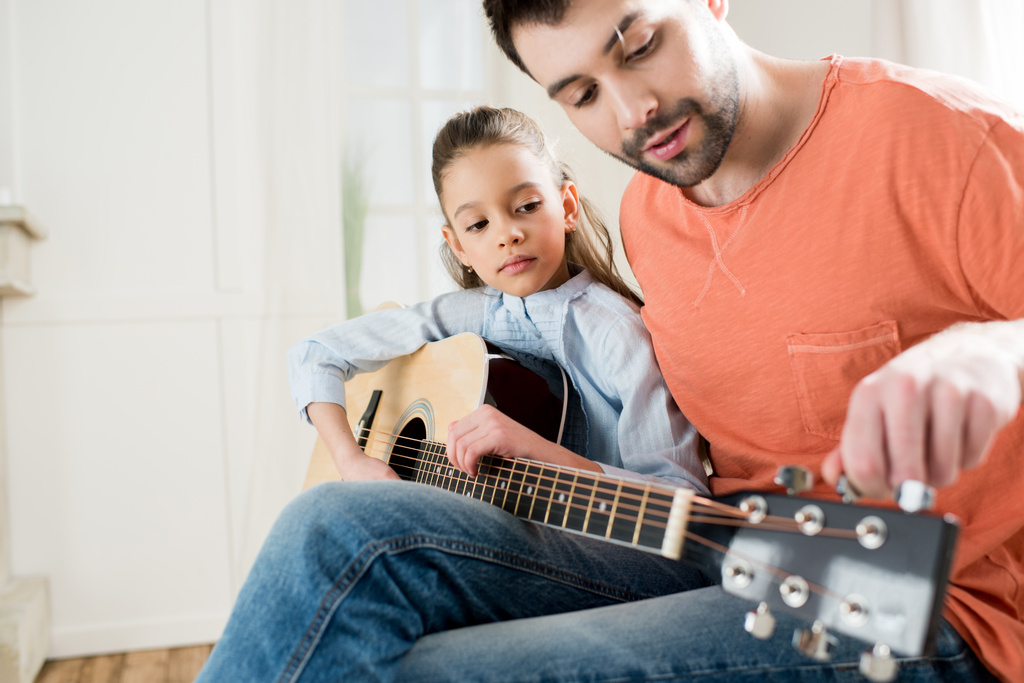 little daughter playing guitar