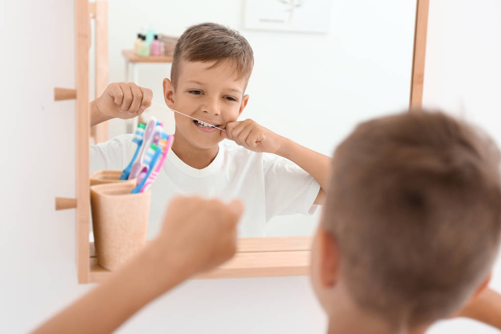 Little boy flossing teeth