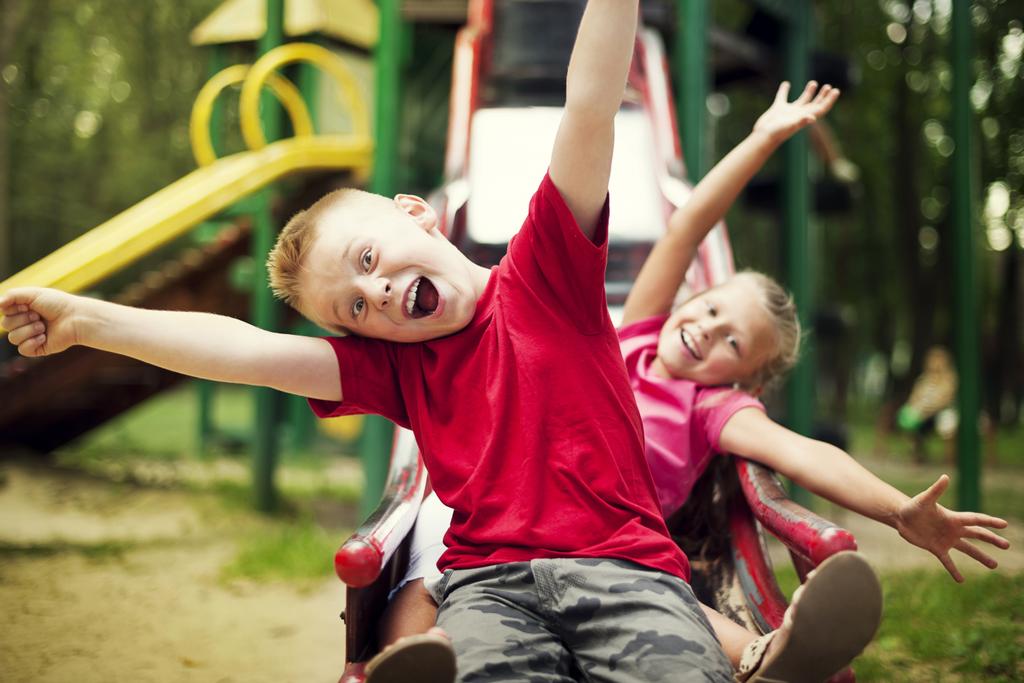 Two kids slide on playground 