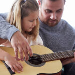 little daughter playing guitar