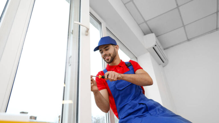 Young worker installing window in flat