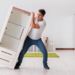 Man moving furniture at home