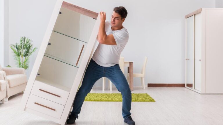 Man moving furniture at home